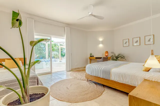 Helles Schlafzimmer mit Doppelbett und Pflanzen.