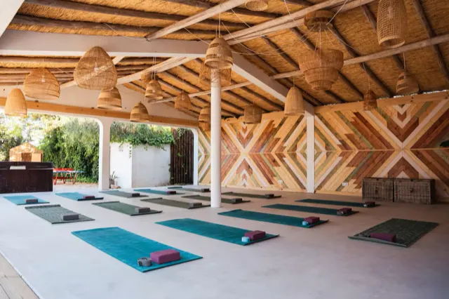 Überdachtes Yoga-Deck mit ausgelegten Matten.